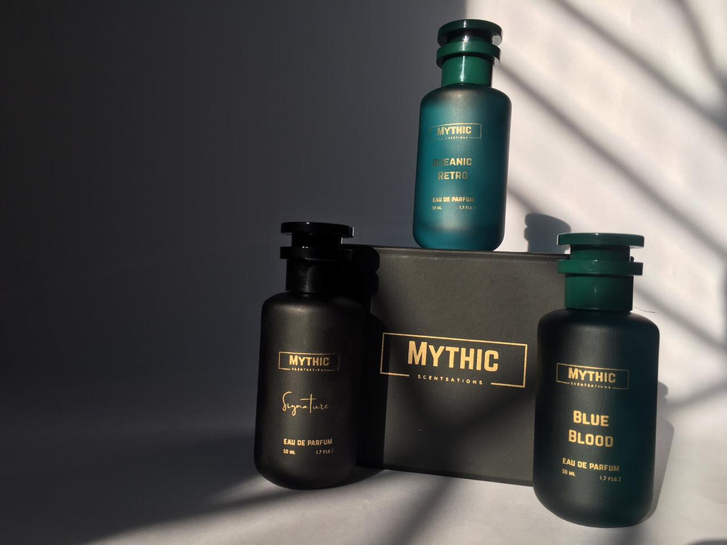 Three Mythic fragrance bottles on a dark surface with a gray background