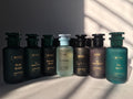 Collection of Mythic perfume bottles on a gray background