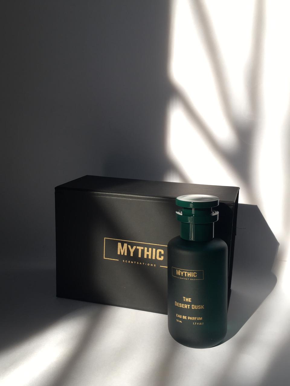 Dark green 'Mythic' perfume bottle with packaging on a gray background